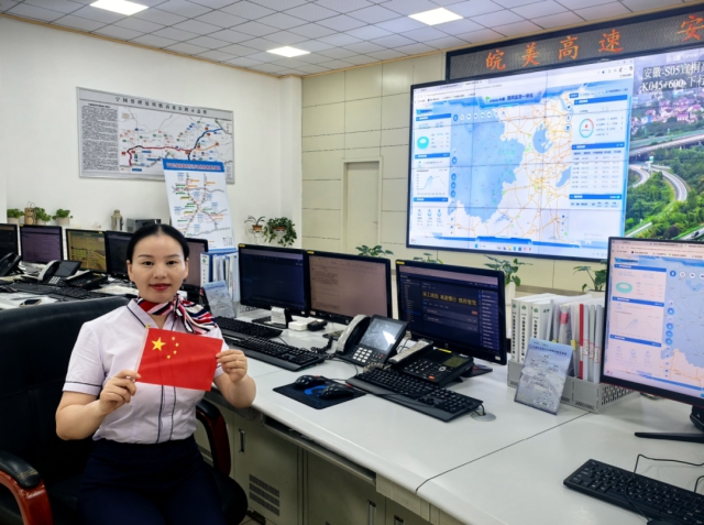 1759889971742443.png 寧宣杭中心監(jiān)控員工作中與國旗合影.png